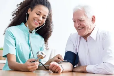 Nurse checking senior man's blood pressue